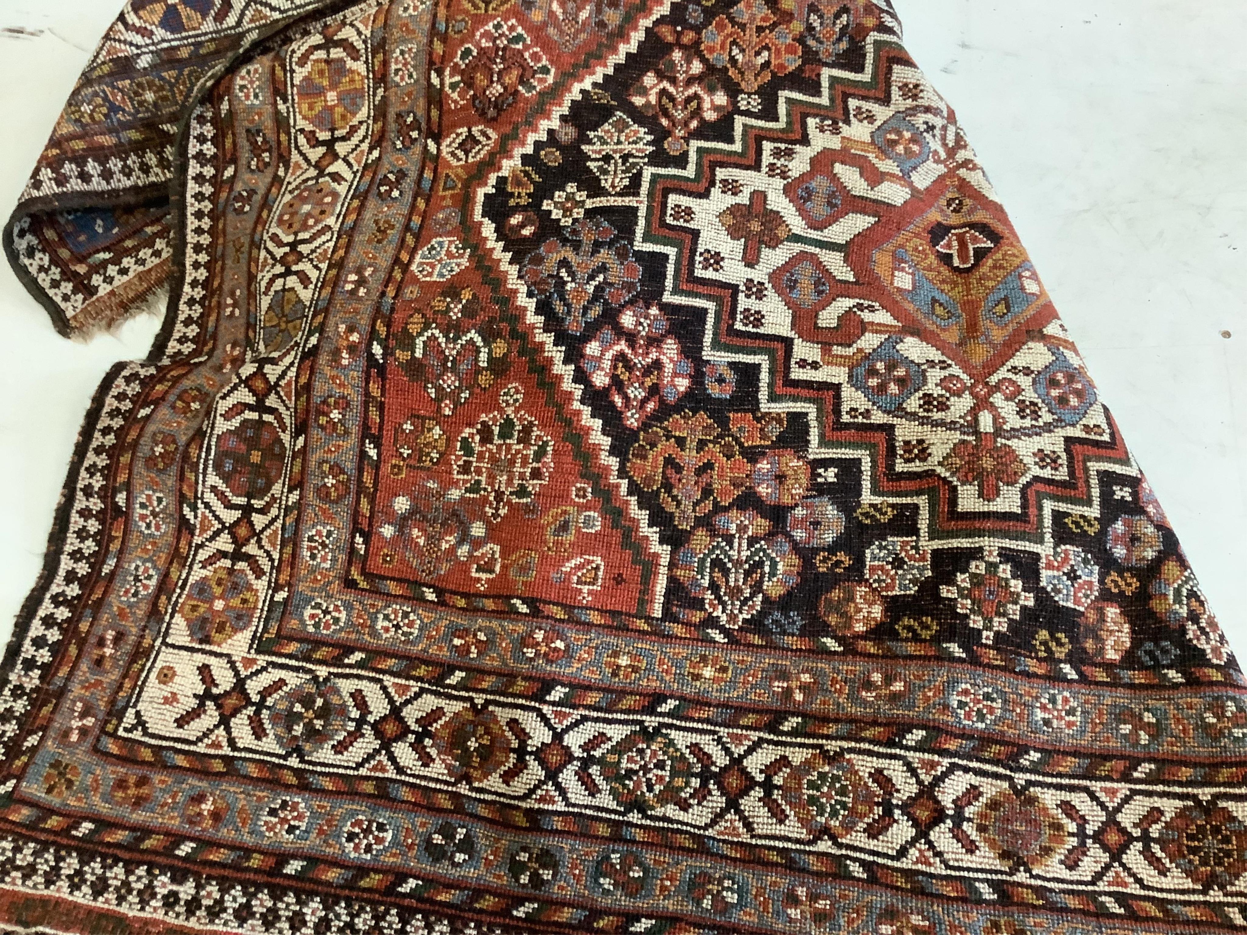 An antique Shiraz triple medallion rug, 230 x 142cm. Condition - poor